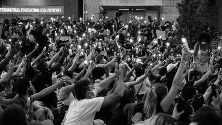 Photo of people holding up phones at protest