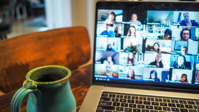 Zoom call meeting on computer with coffee mug